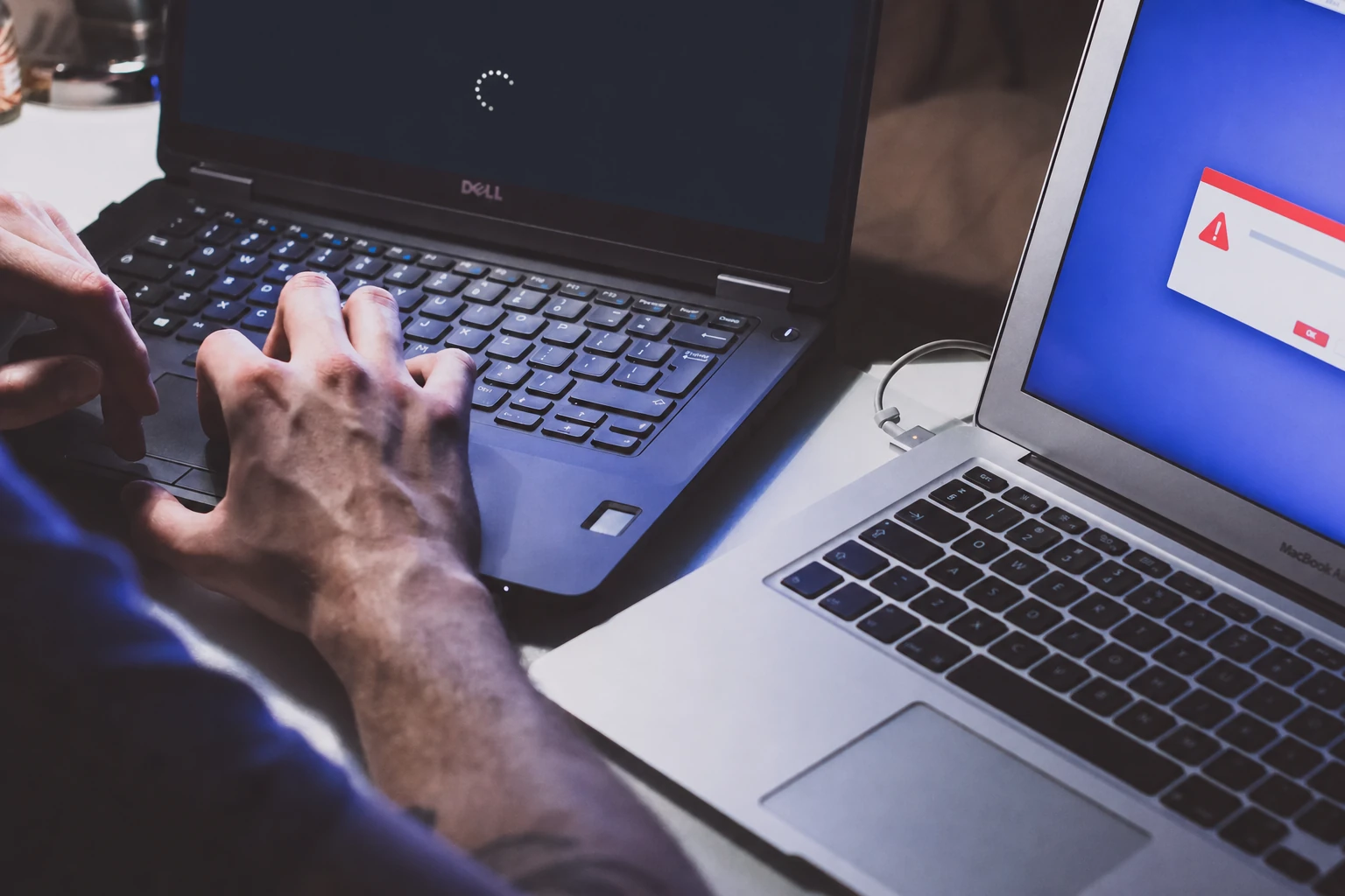 Technician diagnosing software faults on Windows and Mac laptops